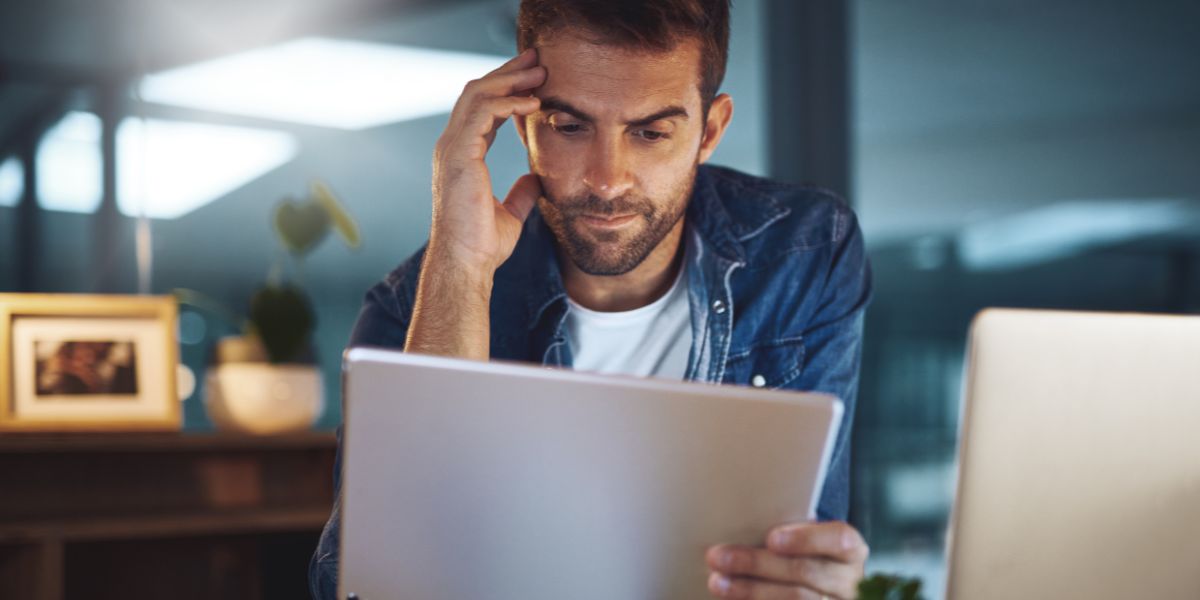 a man reading a tablet thoughtfully